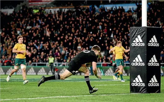  ?? PHOTO: GETTY IMAGES ?? Beauden Barrett runs in the matchwinni­ng try for the All Blacks, much to the delight of fans in the crowd and dismay of the Wallaby on the right.