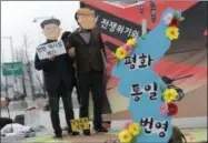  ?? AP PHOTO/ LEE JIN-MAN ?? Protesters wearing masks of U.S. President Donald Trump and North Korean leader Kim Jong Un stand near the map of Korean Peninsula during a rally demanding the denucleari­zation of the Korean Peninsula and peace treaty near the U.S. embassy in Seoul, South Korea, on Thursday.