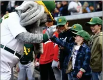  ?? ?? A young Oakland Athletics fan slaps hands with mascot Stomper before the team's spring training game against the Milwaukee Brewers on Friday at Las Vegas Ballpark, a Triple-A stadium.