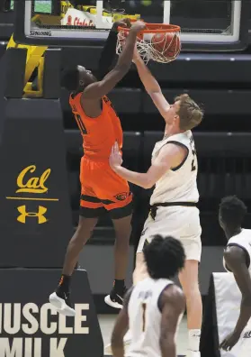  ?? Jed Jacobsohn / Associated Press ?? Oregon State’s Warith Alatishe dunks over Cal’s Lars Thiemann during the second half. The Bears led early, but couldn’t hold off the Beavers.