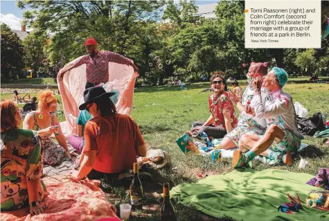  ?? New York Times ?? Tomi Paasonen (right) and Colin Comfort (second from right) celebrate their marriage with a group of friends at a park in Berlin.