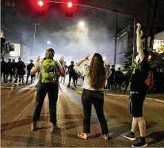  ?? DAVE KILLEN / THE OREGONIAN VIA AP ?? Police and protesters face off in Portland, Ore., last week. Thousands of protesters in the liberal and predominan­tly white city have taken to the streets every day for more than five weeks.