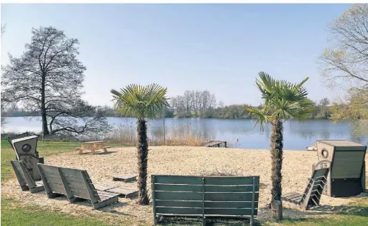  ?? FOTO: REMY ?? Wenn das nicht zu einem Aufenthalt einlädt: Am Strandbad Millinger Meer stehen die Strandkörb­e und auch die Palmen bereits draußen. Und auf der Terrasse wird schon bedient.