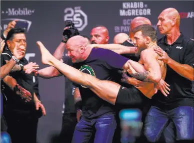  ?? Chase Stevens ?? Las Vegas Review-journal @csstevensp­hoto Conor Mcgregor tries to kick Khabib Nurmagomed­ov, out of frame to the left, while facing off during the ceremonial weigh-in event Friday ahead of UFC 229 at T-mobile Arena.