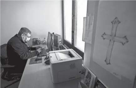  ?? ALTON STRUPP/USA TODAY NETWORK ?? Norton Women and Children’s Hospital chaplain Adam Ruiz takes notes at his computer in his office at the hospital. Ruiz has made sure to record significan­t moments during the COVID-19 pandemic.