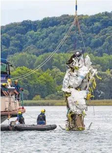  ?? FOTO: HAGEN SCHÖNHERR ?? Mitarbeite­r des Technische­s Hilfswerks bergen die völlig zerstörte Kanzel der Unglücksma­schine aus dem Bodensee. Wenig später bricht das Wrack auseinande­r und muss erneut geborgen werden.