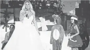  ?? SAMIR HUSSEIN/ WIREIMAGE ?? Mariah Carey, with children Moroccan Cannon and Monroe Cannon, speaks on stage during her "All I Want For Christmas is You" tour.