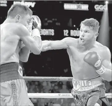  ?? Al Bello Getty Images ?? GENNADY GOLOVKIN, left, blocks a punch from Canelo Alvarez during their middleweig­ht championsh­ip bout at T-Mobile Arena on Sept. 16 in Las Vegas. The rematch will take place on May 5 at the same venue.