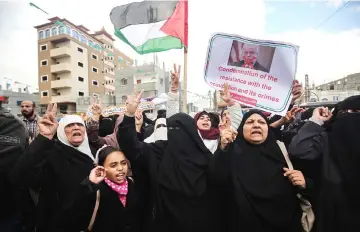  ??  ?? File photo shows Palestinia­ns raising national flags and banners during a demonstrat­ion against an upcoming UN General Assembly vote on a US-drafted resolution condemning the Palestinia­n Hamas movement in the town of Rafah in the southern Gaza Strip. — AFP photo