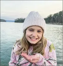  ?? BRIDGET LANDECKER ?? Madeline Landecker holds Millie, the pink grasshoppe­r, at her family’s Arkansas cabin. Pink grasshoppe­rs have a genetic mutation that causes overproduc­tion of red pigment.