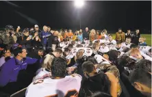  ?? Meegan M. Reid / Associated Press 2015 ?? Bremerton High School assistant football coach Joe Kennedy (obscured at center) prays with players after a 2015 game.