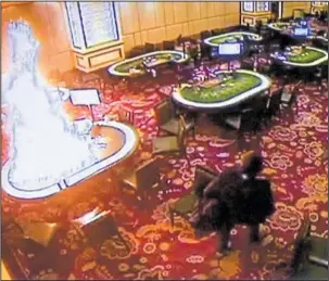  ?? The Associated Press ?? VIDEO: In this image made from security video released by Manila Police and Resorts World Manila on Saturday, a gunman walks away after setting fire to a gambling table in the Resorts World Manila entertainm­ent and gambling complex in suburban Pasay...