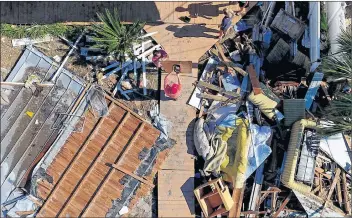  ?? AP PHOTO ?? The Wood family begins cleanup efforts among the debris of their damaged home from hurricane Michael in Mexico Beach, Fla., Sunday.