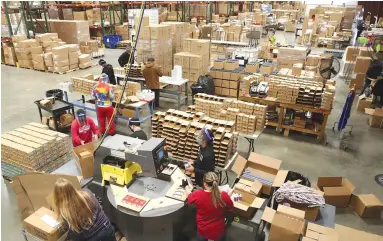  ?? The Sentinel-Record/Richard Rasmussen ?? Employees at Tanners Team Sports and Vulcan Sporting Goods Inc., which has stayed alive during the pandemic by selling face masks, work in the company’s facility at 736 Mid-America Blvd., on Tuesday.