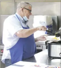  ?? Brodie Johnson • Times-Herald ?? The Graham Memorial Presbyteri­an Church Soup Kitchen has establishe­d a drive-through for those in need to swing through and pick up plates to go to promote social distancing during the Covid-19 pandemic. Soup Kitchen volunteer Bill Swearengin makes a plate for people to pick up.