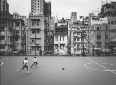  ?? @BRIANLHY_ / INSTAGRAM ?? Two boys race for the ball while playing soccer at the Blake Garden field, with old buildings of Sheung Wan providing a backdrop.