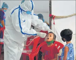  ??  ?? A health worker collects the swab sample of a child at Manpada, Thane, on Friday.