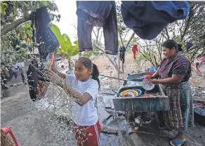  ??  ?? Melissa Sical and her mother, Maria Elvira Ramos, use well water to wash dishes in Baja Verapaz. The family is struggling to pay for a failed trip to the USA.