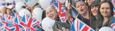  ?? Photos by Getty Images ?? Confetti falling, flags flying: On May 16, Harrods department store employees celebrated Queen Elizabeth II’s upcoming Diamond Jubilee.