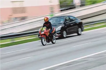  ?? PIC BY ASYRAF HAMZAH ?? A motorcycle speeding in the right lane of the Federal Highway in Petaling Jaya.