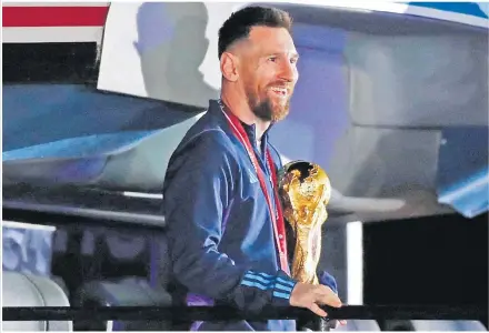  ?? Picture: REUTERS ?? Argentina’s Lionel Messi with the trophy during the team’s arrival at Ezeiza Internatio­nal Airport.