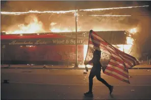  ?? PICTURE: AP ?? PROTEST: A man carries the US flag upside down, a sign of distress, in Minneapoli­s.