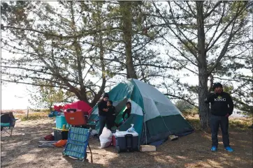  ?? ANDA CHU — STAFF PHOTOS ?? Isau Sandoval, far right, talks on his phone Thursday next to his tent at Doran Regional Park in Bodega Bay. Sandoval and his family have been camping to avoid the thick smoke fromsevera­l wildfires burning hear their home in Santa Rosa.