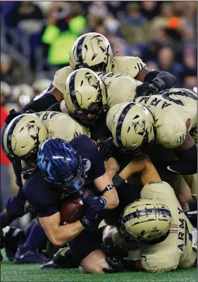  ?? Associated Press ?? Army strong: Navy fullback Alex Tecza is gang tackled by Army defenders during the second quarter Saturday at Gillette Stadium in Foxborough, Mass.