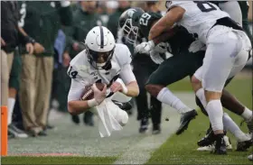  ?? AL GOLDIS - THE ASSOCIATED PRESS ?? Penn State quarterbac­k Sean Clifford, left, dives for a first down against Michigan State’s Shakur Brown (29) during the first quarter of a game, Saturday, Oct. 26, 2019, in East Lansing, Mich.