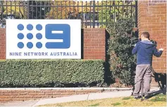  ??  ?? A television cameraman films the logo of Nine Entertainm­ent Co Holdings Ltd on display outside their Sydney headquarte­rs in Australia. — Reuters photo
