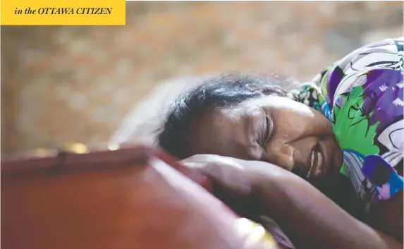  ?? GEMUNU AMARASINGH­E/THE ASSOCIATED PRESS ?? Lalitha weeps Monday on the coffin containing the remains of her niece, Sneha Savindi, 12, a victim of Easter Sunday’s bombing at St. Sebastian Church in Negombo, Sri Lanka.