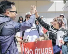  ??  ?? IRVINE RESIDENTS David Su, left, and May He celebrate the Orange County Board of Supervisor­s’ decision to rescind the shelter plan.