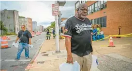  ?? JERRY JACKSON/BALTIMORE SUN ?? Kelis Stewart, 70, carries three gallons of water from the DPW distributi­on location at Harlem Park Elementary School Tuesday afternoon.