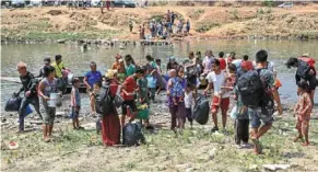  ?? ?? Fleeing to safety: People crossing the Moei River as they flee Myawaddy township in Myanmar to Thailand’s Mae Sot town in Thailand’s Tak province. — AP