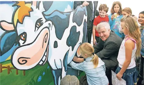  ?? ARCHIVFOTO: DPA ?? Da lacht die Kuh und der (damals Agrar-)Minister freut sich. Doch die Mutter aller Nahrungsmi­ttel hat inzwischen an Schulen einen schweren Stand.