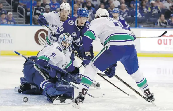  ?? — THE ASSOCIATED PRESS ?? Canucks goaltender Anders Nilsson makes a pad-save on a shot by Tampa Bay Lightning centre Vladislav Namestniko­v, centre, during the second period on Thursday in Tampa, Fla. Canucks defenceman Christophe­r Tanev looks on.