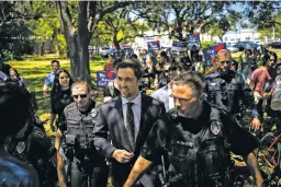  ?? THOMAS SIMONETTI/WASHINGTON POST FILE PHOTO ?? Christophe­r Rufo, a conservati­ve activist and New College of Florida trustee, walks through protesters last month on his way out of a bill-signing event featuring Florida Gov. Ron DeSantis in Sarasota, Fla. Rufo helped write model legislatio­n this winter to “abolish DEI bureaucrac­ies” at public universiti­es.