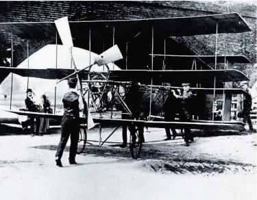  ??  ?? A.V.Roe with workers and his triplane prototype under the railway arch in 1909