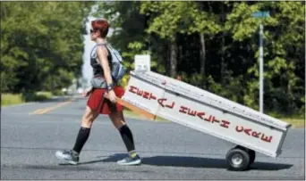 ?? AP PHOTO/MEL EVANS ?? Greta Schwartz is dressed like a Spartan warrior pulling a casket as she walks along route 206, from southern New Jersey to Trenton, May 31, 2016.