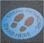  ??  ?? A blue dot on the floor at Angstadt Family Dentistry reminds patients to socialdist­ance.