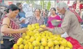  ?? AP ?? A woman buys mangoes from a street vendor in New Delhi.