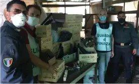  ??  ?? Italian police with the haul of counterfei­t Tuscan wine. Photograph: Guardia di Finanza, Firenze