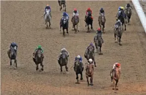  ?? AP PHOTO/CHARLIE RIEDEL ?? Rich Strike, with Sonny Leon aboard, lower right, lead the pack as they cross the finish line to win Saturday’s Kentucky Derby at Churchill Downs.