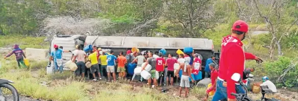  ??  ?? CON RECIPIENTE­S DE PLÁSTICO, este grupo de personas saquean el combustibl­e que transporta­ba el camión, momentos previos a su explosión ayer en Pueblo Viejo, departamen­to del Magdalena.