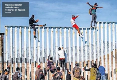  ?? /ARCHIVO ?? Migrantes escalan parte del muro fronterizo en Tijuana.