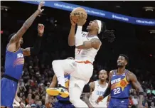  ?? AP photo ?? Los Angeles Clippers’ Terance Mann drives to the basket between Phoenix Suns’ Torrey Craig, (left) and Deandre Ayton during the first half Thursday