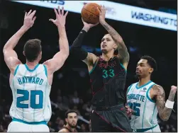  ?? Associated Press ?? Taking aim: Washington Wizards forward Kyle Kuzma (33) looks to shoot over Charlotte Hornets forwards Gordon Hayward (20) and P.J. Washington (25) during the second half of an NBA basketball game Friday in Washington. The Hornets knocked off the Wizards 124-117.