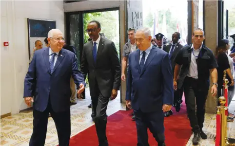  ?? (Ronen Zvulun/Reuters) ?? RWANDAN PRESIDENT Paul Kagame is flanked by President Reuven Rivlin and Prime Minister Benjamin Netanyahu as he arrives yesterday at the President’s Residence in Jerusalem.