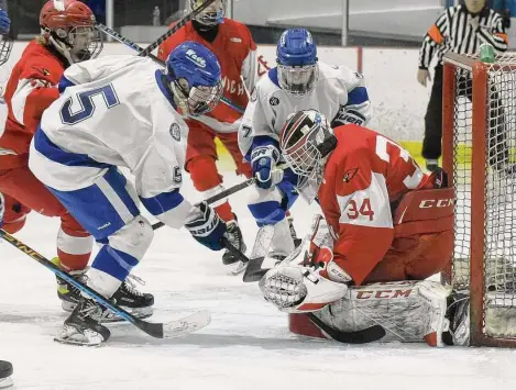  ?? Dave Stewart/Hearst Connecticu­t Media ?? Greenwich goalie Nicholas Sinisi blocks a shot by Darien’s Chris Davis (5) during the FCIAC boys ice hockey semifinals at the Darien Ice House on Wednesday.