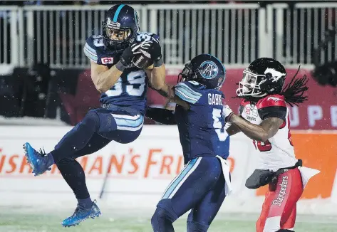  ?? THE CANADIAN PRESS ?? Argonauts defender Matt Black, left, makes a Grey Cup-clinching intercepti­on of a pass intended for Calgary’s Marken Michel.